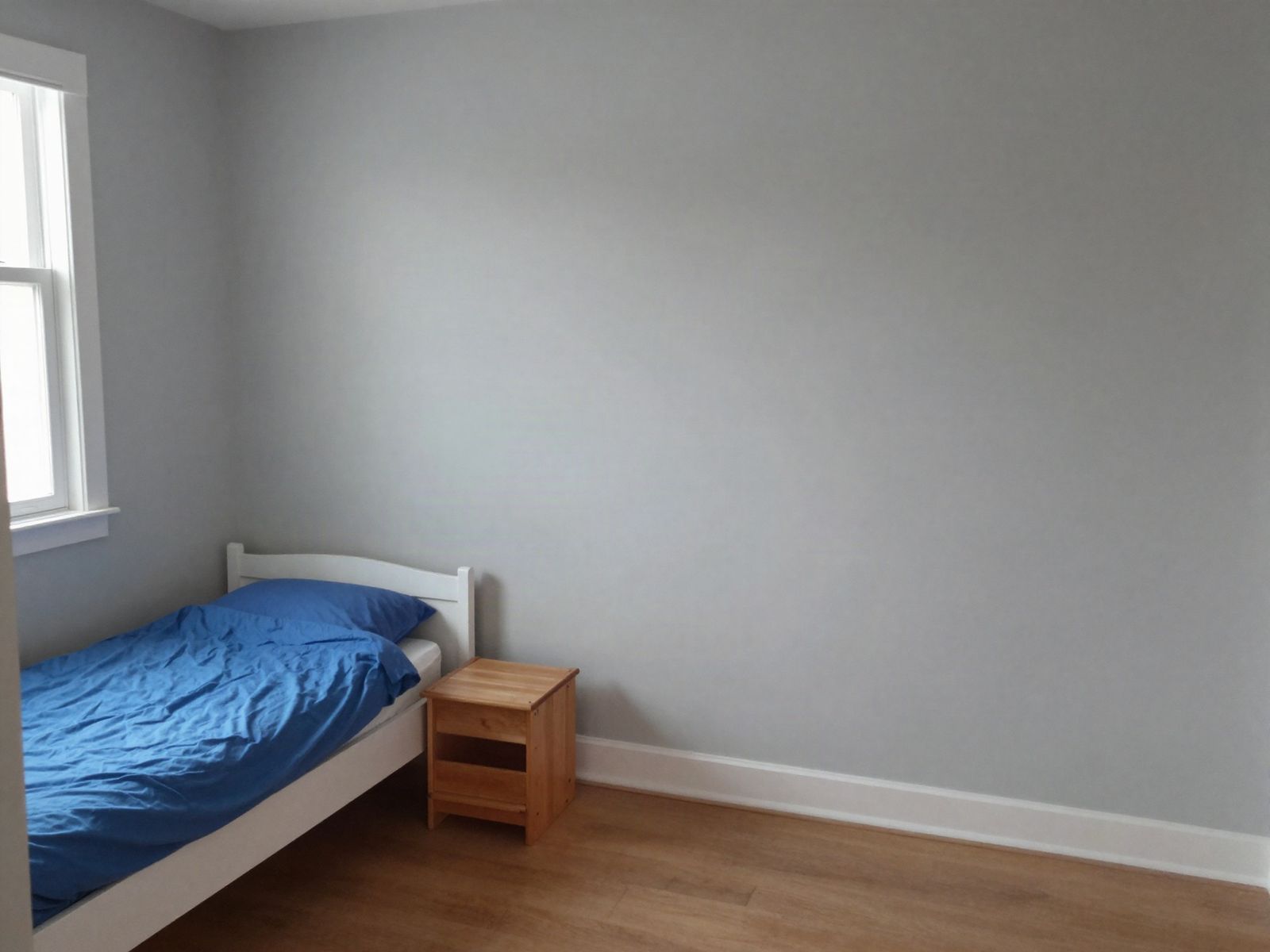 A plain grey bedroom wall before the mural